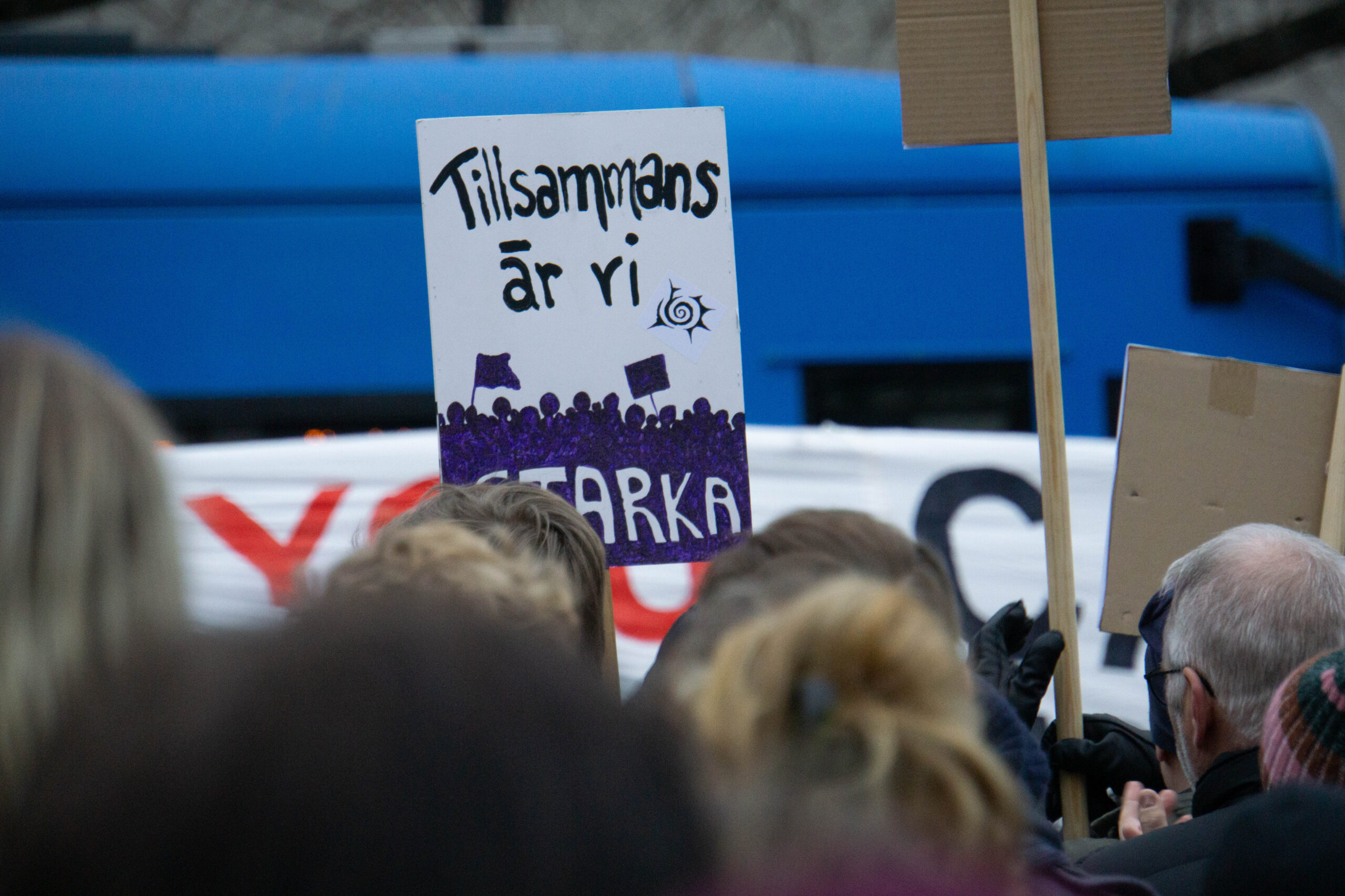 Under en demonstration i Stockholm bär en demonstrant en skylt med texten ”Tillsammans är vi starka”. Foto: Johannes Ernstberger